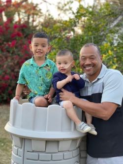 Father and two sons posing for camera