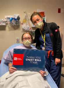 Masked doctor next to masked patient in bed