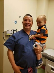 Provider holding toddler in striped shirt
