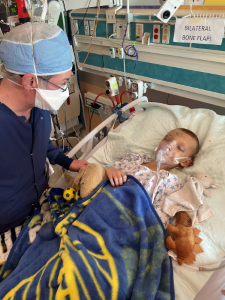 Child in hospital bed with provider looking on