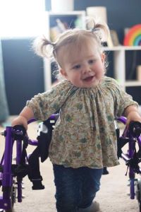 Toddler standing with medical walker