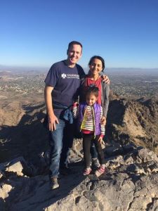 Family of 3 posing on mountaintop