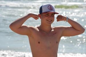Shirtless teen flexing his biceps