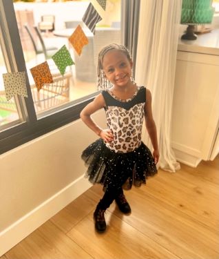 Smiling child posing in a black tutu