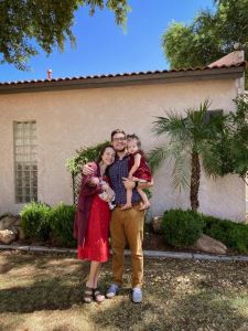 Family of 4 posing in front of house
