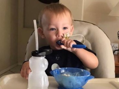 Toddler feeding self in highchair