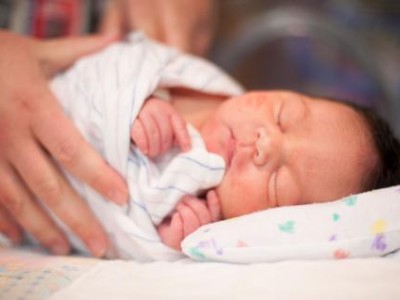 Newborn wrapped in striped blanket