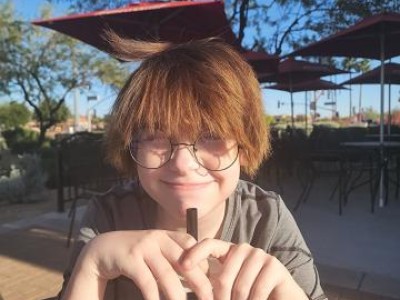 Teen wearing glasses, smiling at camera
