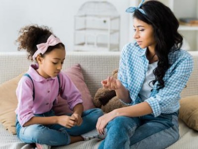 Mother and daughter talking on couch