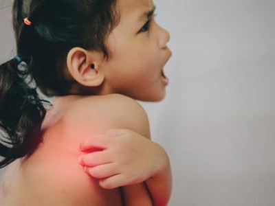 Young girl scratching her back