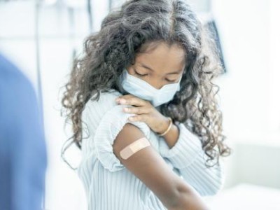 Masked girl with bandage on arm