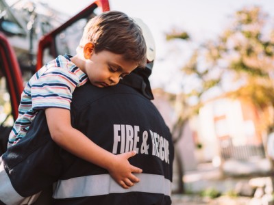 Firefighter holding young boy