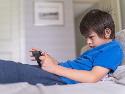 Boy straining his neck while using a tablet