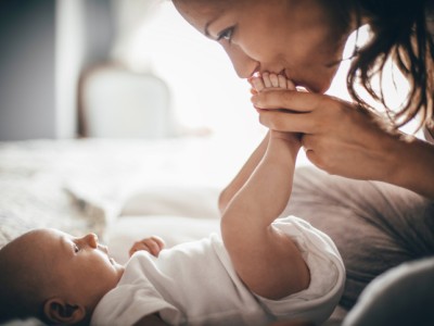 Mother kissing newborn baby's feet