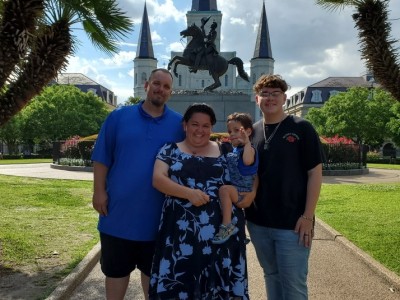 Family of 4 posing in courtyard