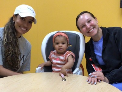 Mom, child, and occupational therapist sitting at table and smiling