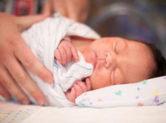 Newborn wrapped in striped blanket
