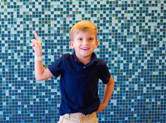 Kid against file wall pointing