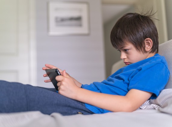 Boy straining his neck while using a tablet