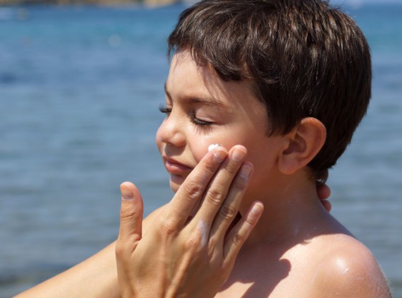 Child getting sunscreen applied to face