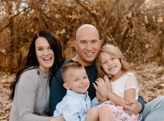 Family of 4 posing in the leaves