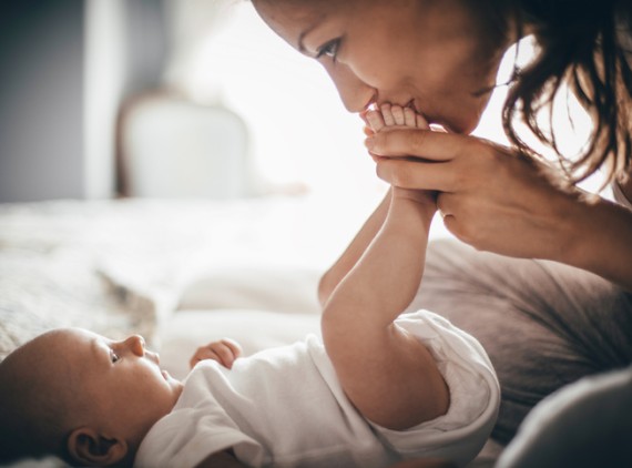Mother kissing newborn baby's feet