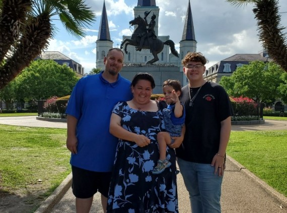 Family of 4 posing in courtyard